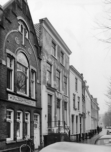 848061 Gezicht op de voorgevel van het pand Nieuwegracht 87 (links, Wijkgebouw Nicolaïkerk), de vervallen voorgevel van ...